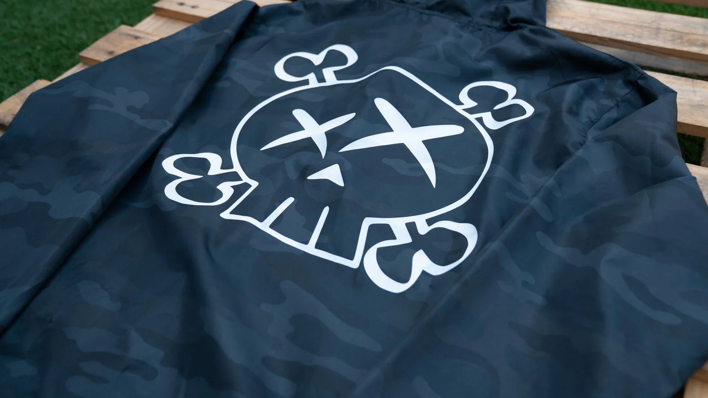 Navy blue jacket with a white skull and crossbones design on a wooden surface.