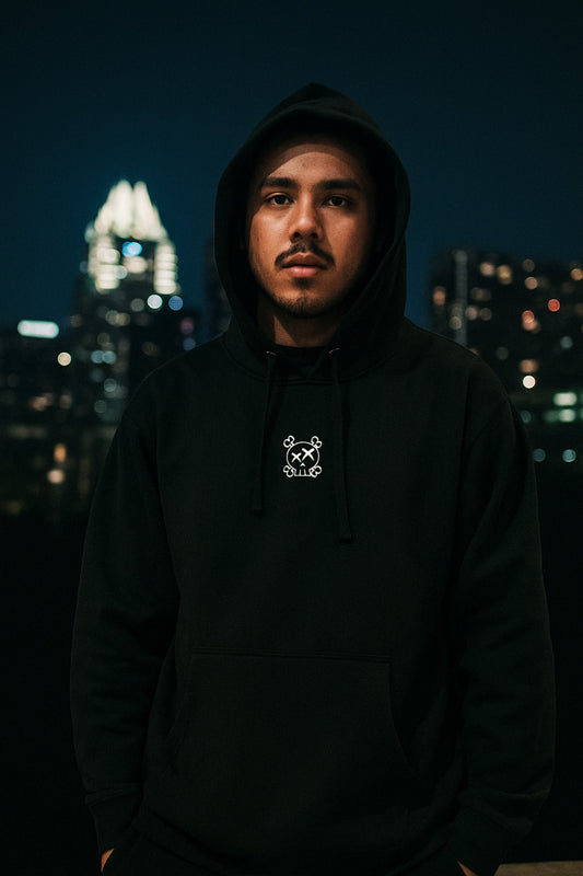 Person wearing a black hoodie with a  cityscape in the background