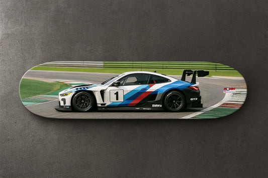Skateboard with a BMW M4 GT4 racing car design on a gray background