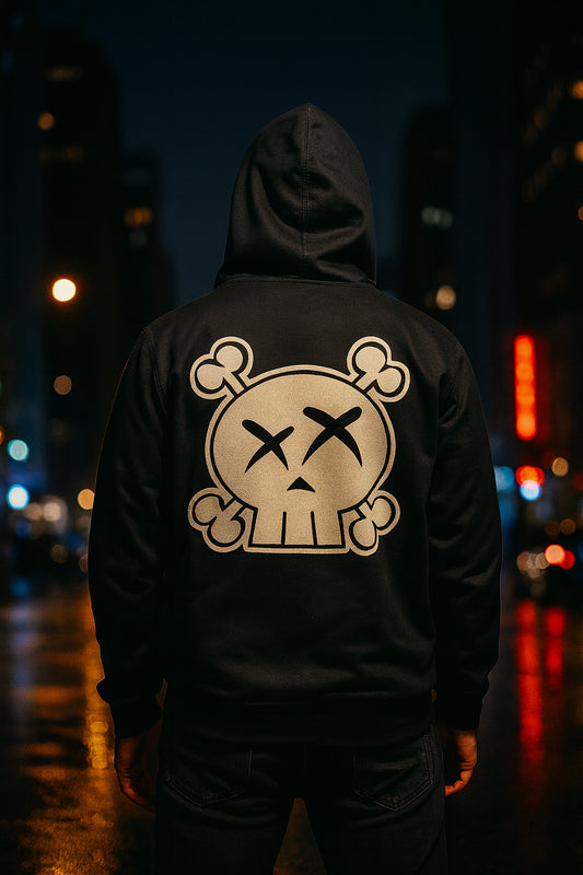 Person wearing a black hoodie with a skull design on the back, standing in an urban night setting.