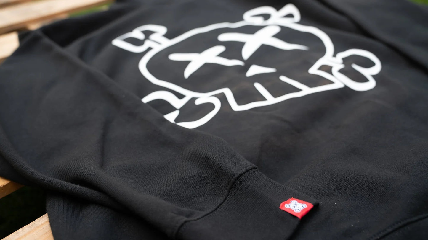 Black sweatshirt with a white skull graphic design on a wooden surface