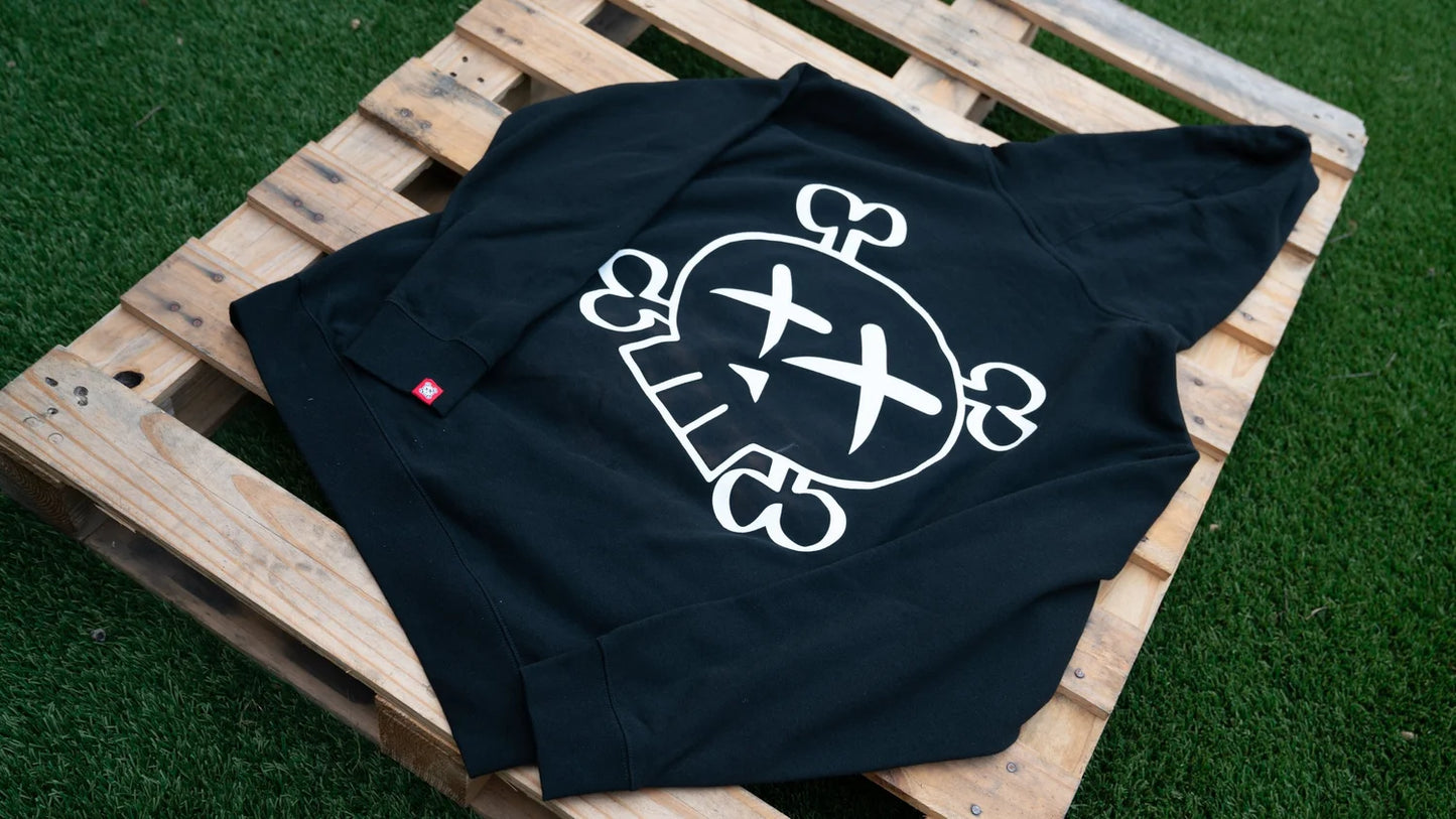 Black t-shirt with a white graphic skull design on a wooden pallet