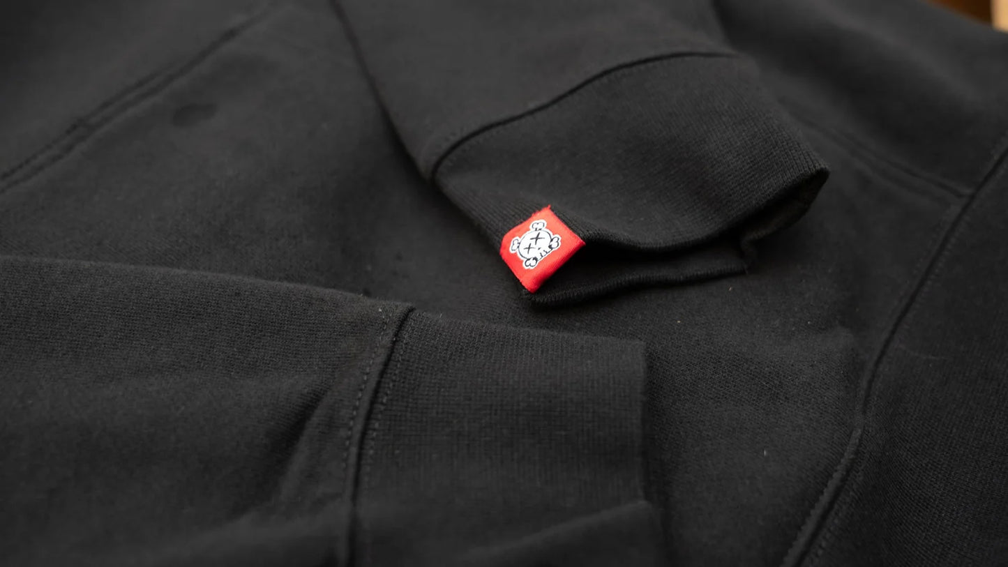 Close-up of a black sleeve with a red label featuring a white skull logo.