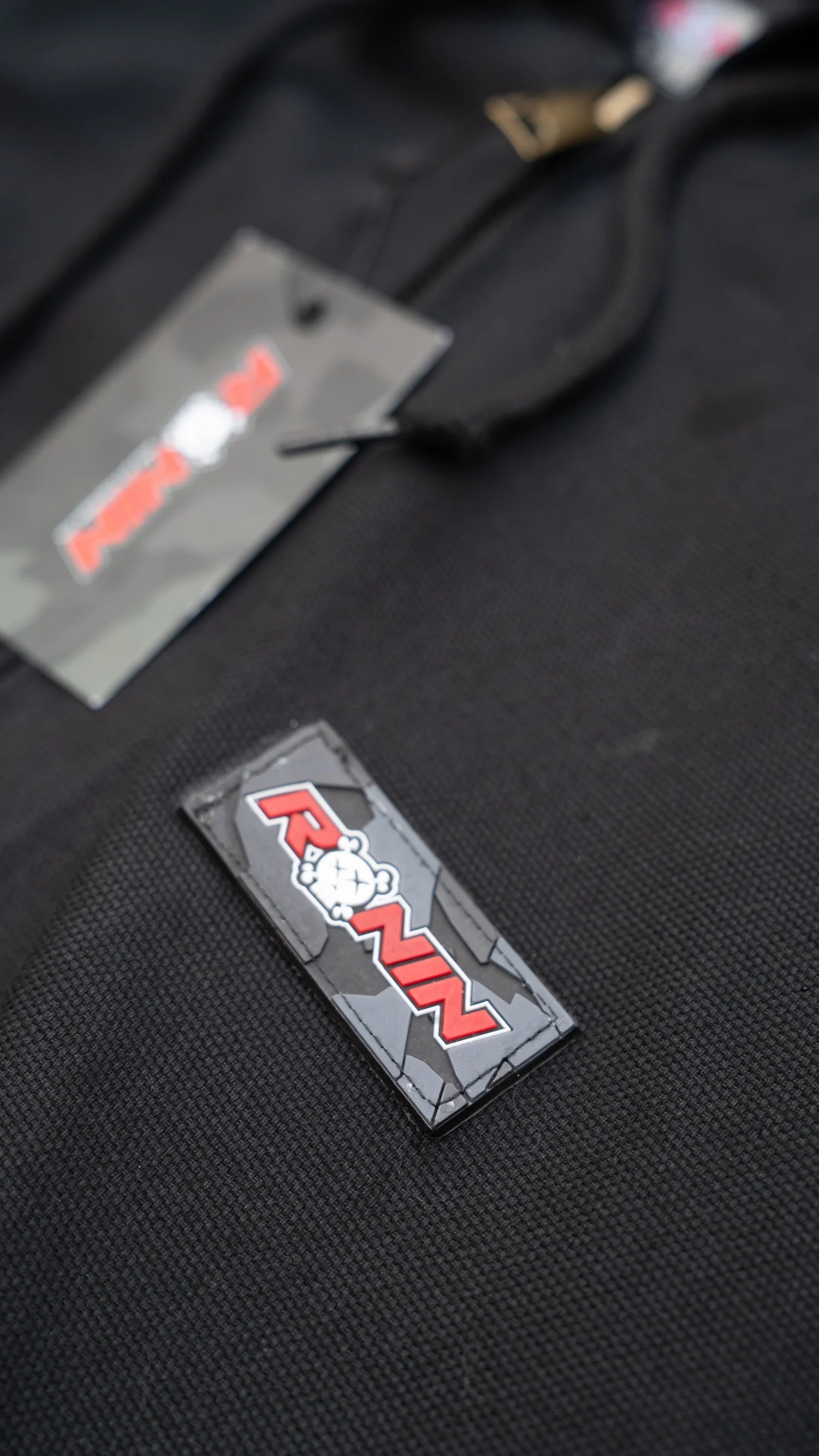 Black jacket with a patch and a tag on a black background