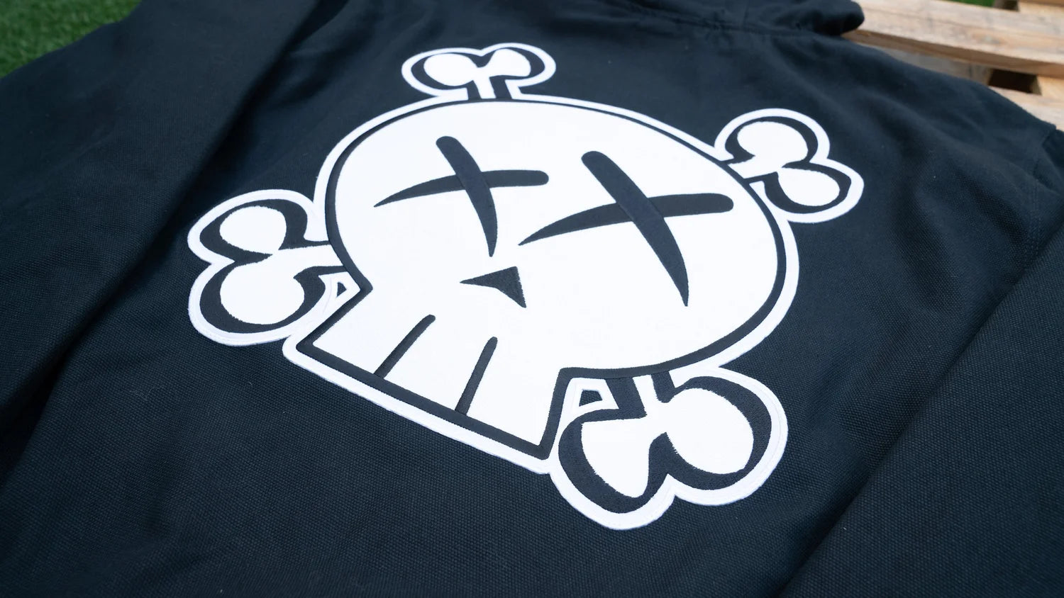 Black hooded jacket  with a white graphic design on a wooden surface