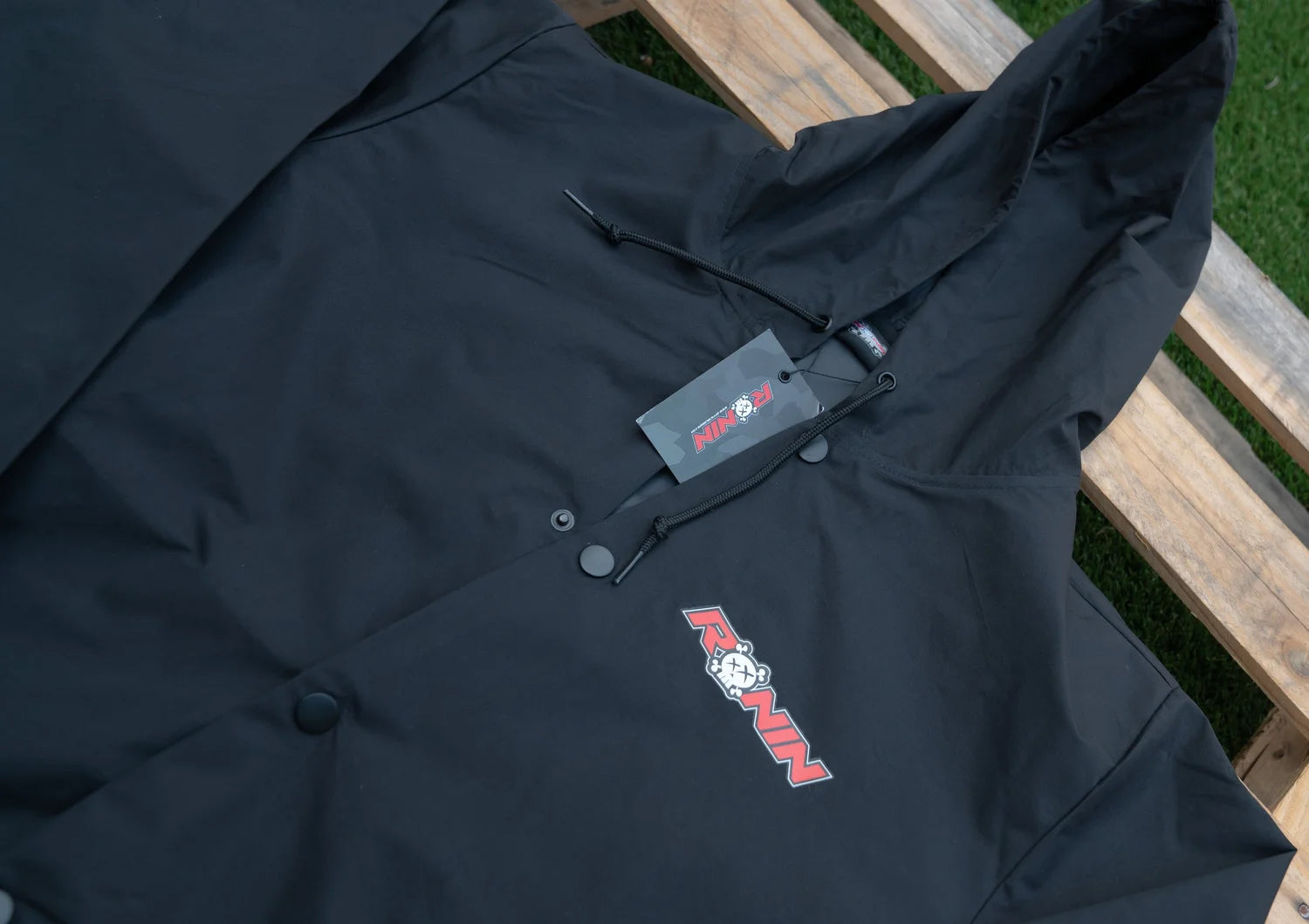 Black jacket with a brand logo on a wooden surface