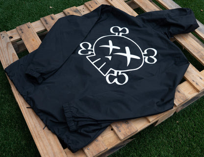 Black Hooded Jacket with a white graphic skull logo design on a wooden pallet