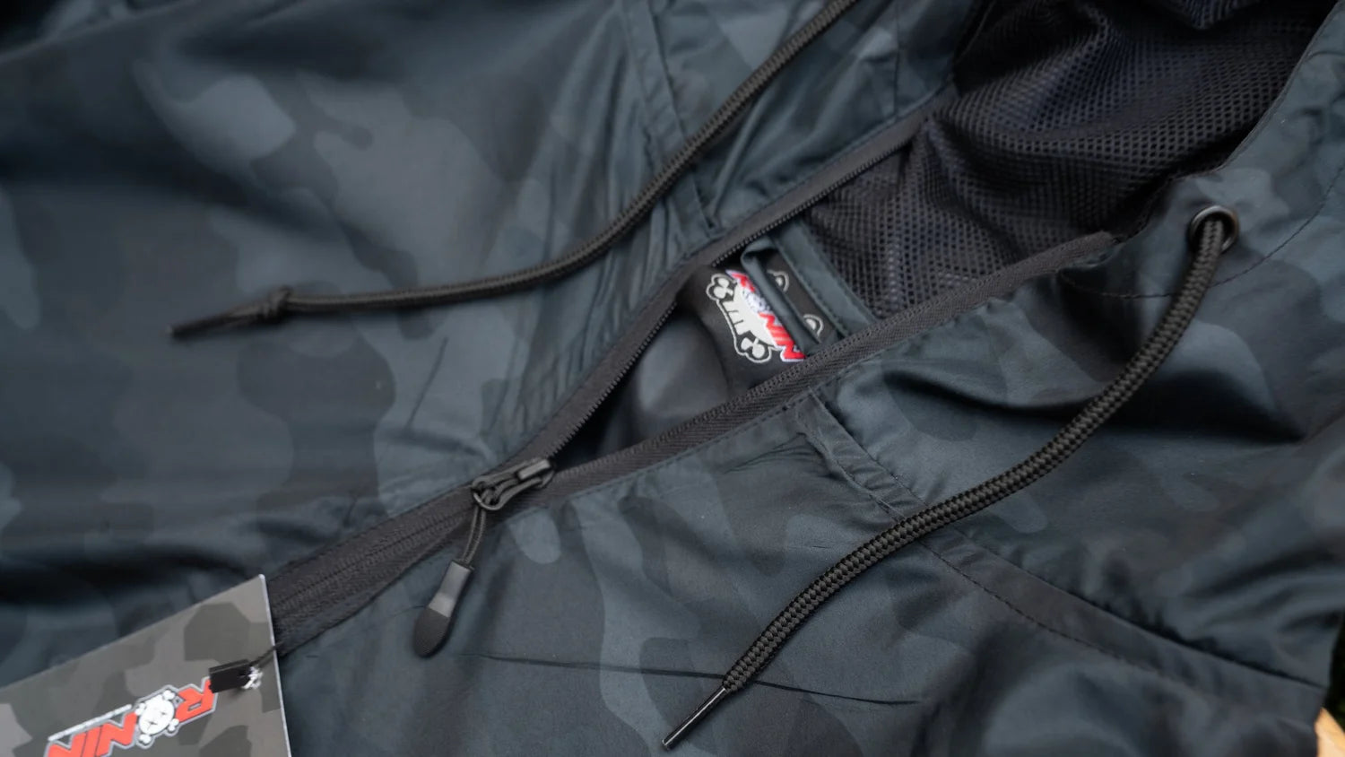 Close-up of a black jacket with a zipper and visible brand logo.