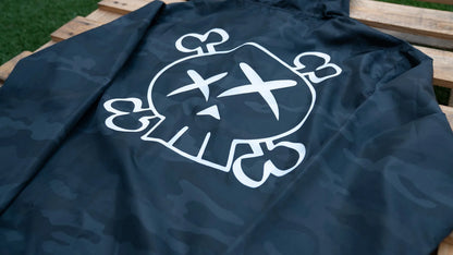 Navy blue jacket with a white skull and crossbones design on a wooden surface.