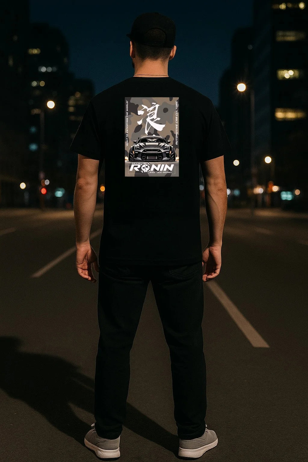 Person wearing a black t-shirt with 'Ronin' logo and a Nissan GTR design on the back, standing on a dark street.