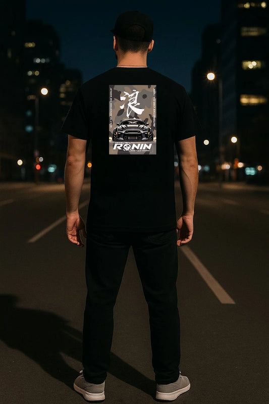Person wearing a black t-shirt with 'Ronin' logo and a Nissan GTR design on the back, standing on a dark street.