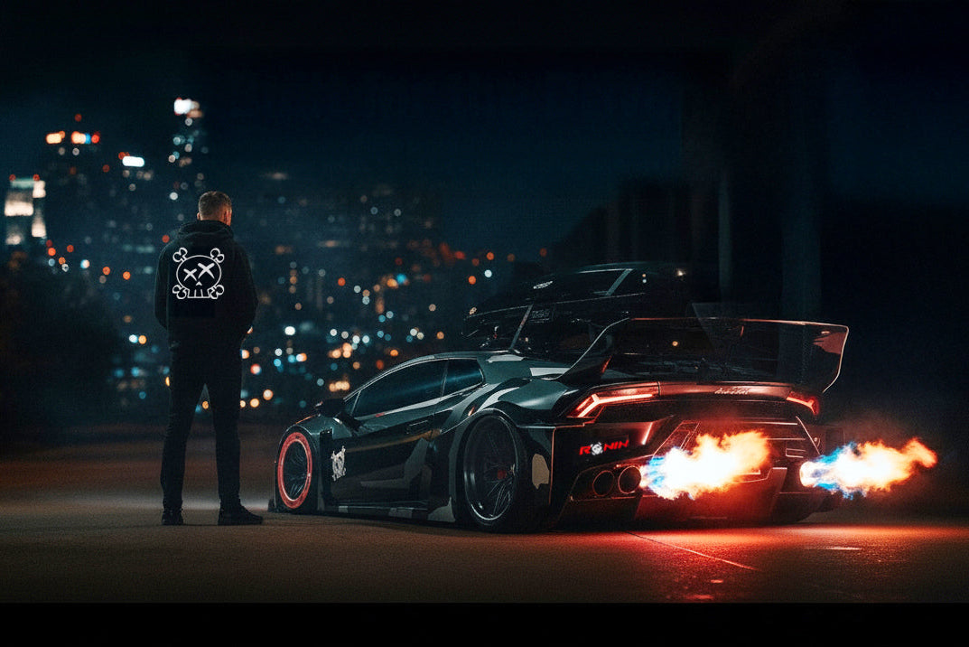 Man standing next to a futuristic car with flames on a city street at night