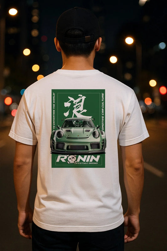 Person wearing a white t-shirt with a Porsche GT3RS graphic design on the back, standing on a street at night.