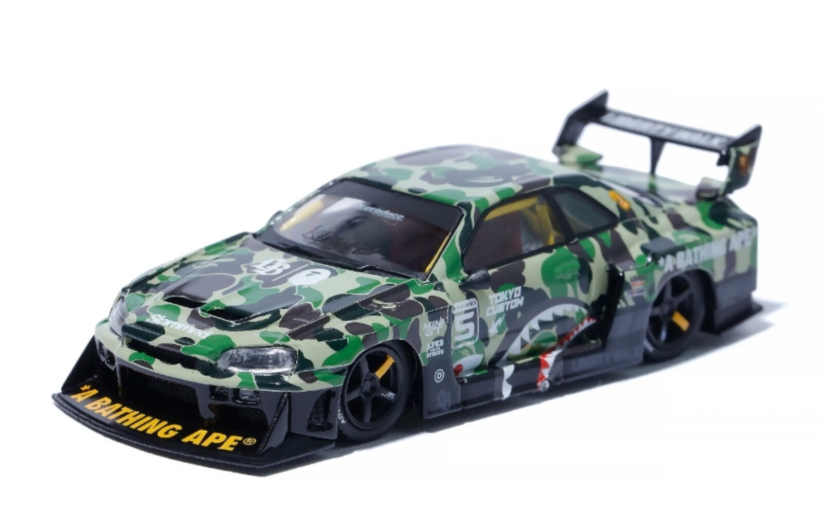 Camouflage-patterned model car with 'Bathing Ape' branding on a white background